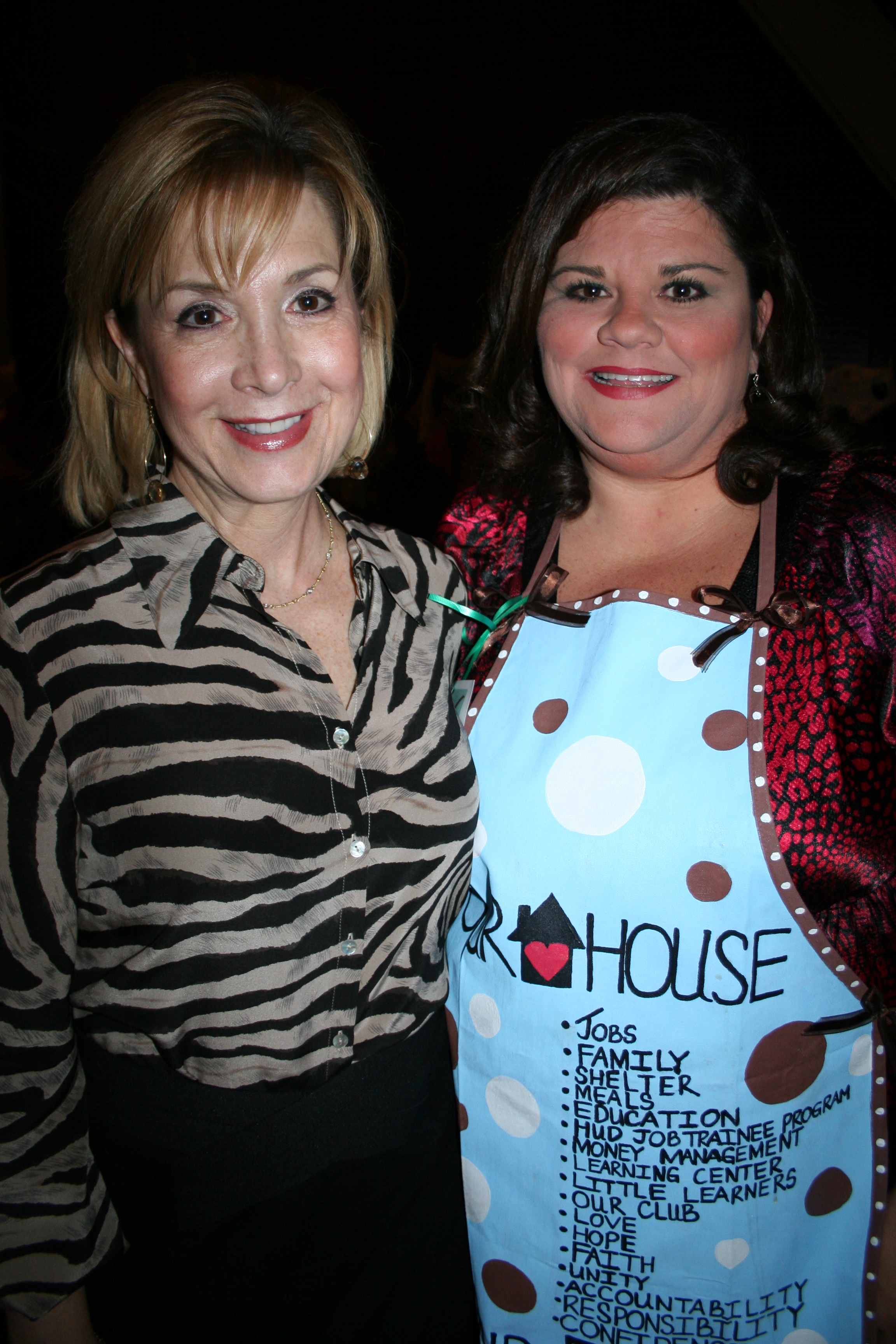 Debi Barnes with Our House resident Janis Newberry modeling an apron she designed.
