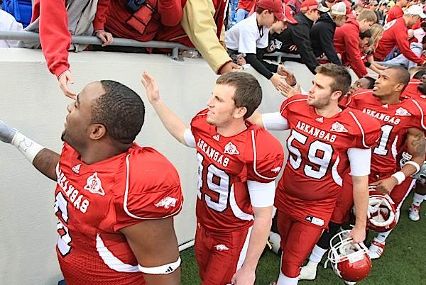 Arkansas deep snapper Rhett Richardson, third from left, and his teammates shake hands with fans following the Mississippi State game Nov. 21 in Little Rock. 