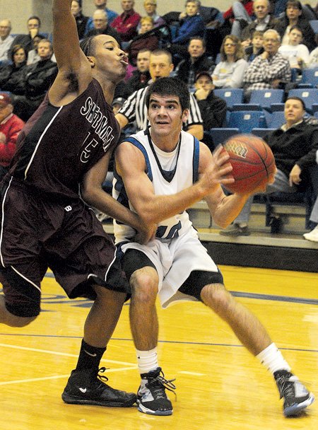 Rogers High’s Brandon Gentz, right, goes to the basket during Saturday’s game against Sherman, Texas, at Rogers High School.