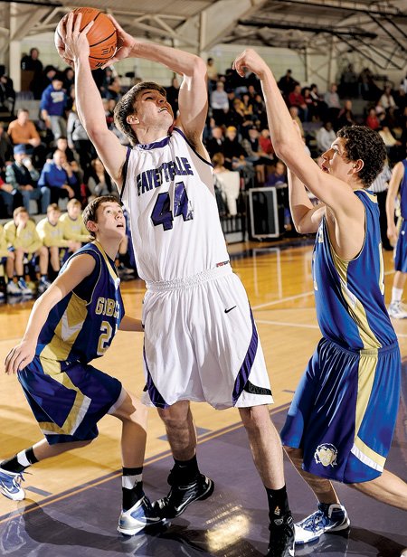 Fayetteville senior Colton Primm, center, takes a shot in the lane as Harrison junior John Colliver, right, reaches to defend during the first half of Saturday’s game at Fayetteville High.