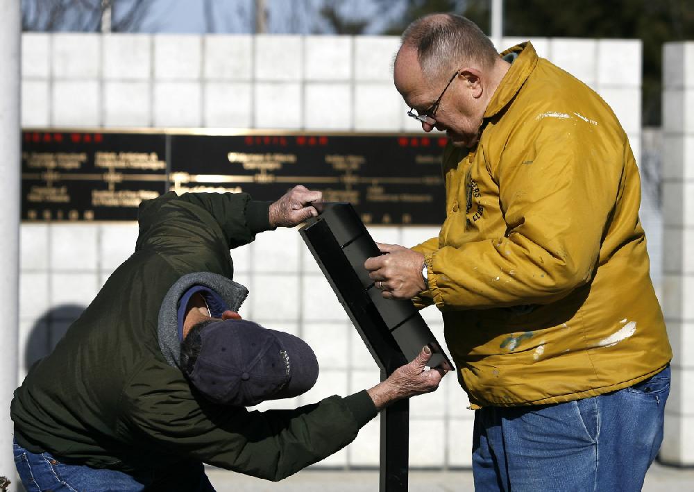 Arkansas Democrat-GazetteBOB COLEMAN--122109--Jim Sperry of Bella Vista (left) and Rex Hickox of Bentonville put together a stand for a plaque at the Veterans Wall of Honor in Bella Vista Monday afternoon. The plaque is one of two recently placed at the entrance to the memorial.