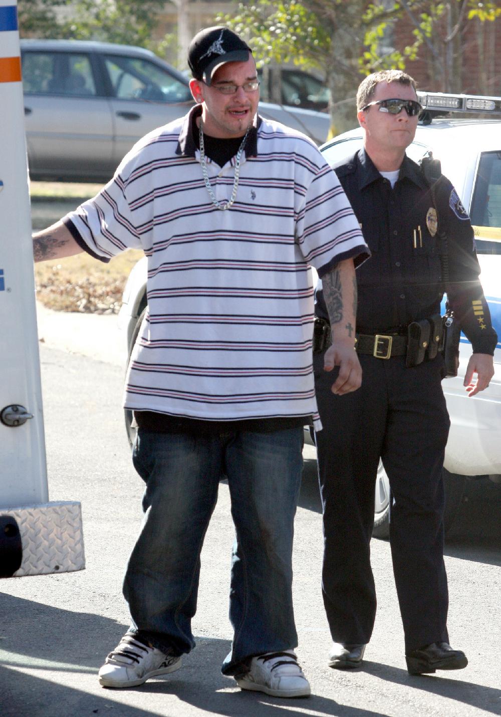Arkansas Democrat-GazetteRICK MCFARLAND--122109-- A North Little Rock Police Officer escorts an unidentified man who along with a female found the body of their roommate at their residence, 4421 Augusta St., in North Little Rock Monday morning. It is being investigated as a possible homicide.