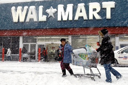 Shoppers struggle with their cart Saturday in Philadelphia, where nearly two feet of snow fell, disrupting Christmas shopping.
