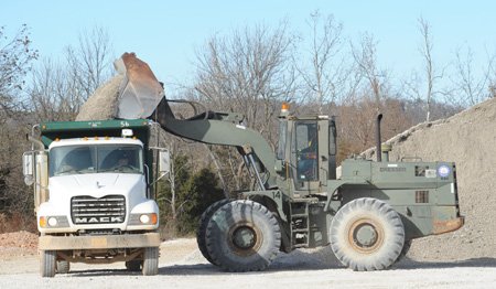 Washington County workers load gravel on Dec. 17 into a dump truck at the county’s Maintenance and Operations Center in Fayetteville.
