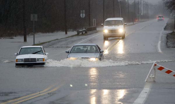Cars  drive through the bumper-deep standing water on North Hills Blvd in the Dark Hollow area after overnight rains flooded the area in North Little Rock, December 24, 2009.