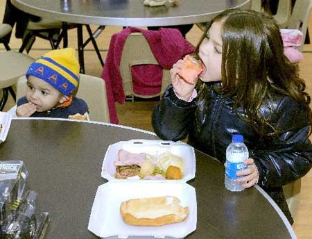 Orion General, 2, and Alissa Creech, 7, eat a Christmas dinner Friday at the Bentonville Church of Christ during the annual B&B Fund Drive in Bentonville.
CHRISTMAS DINNER