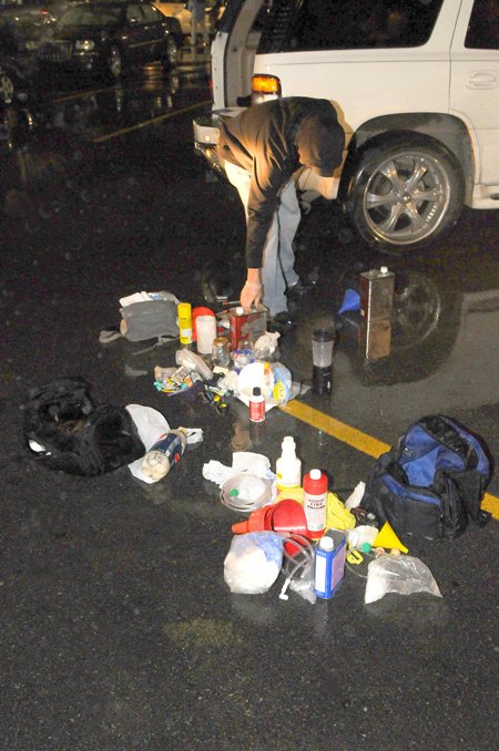 An undercover officer removes contents of a methamphetamine lab from the rear of a sport utility vehicle shortly after 6 p.m. Thursday in the parking lot of the Walmart Supercenter on Walnut Street in Rogers.