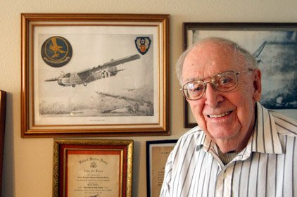 Former World War II glider pilot Doug Maltby stands before a drawing of a Waco CG-4A combat glider at his home in Hot Springs Village.