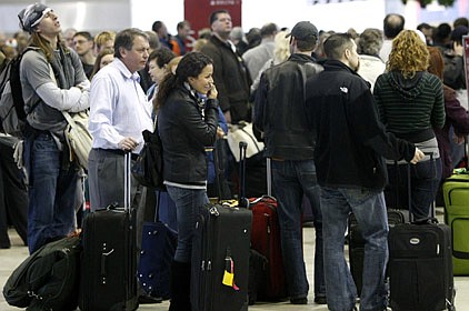 Holiday travelers wait in line Sunday at the Detroit Metropolitan Airport in Romulus, Mich., after the U.S. government tightened airline security.