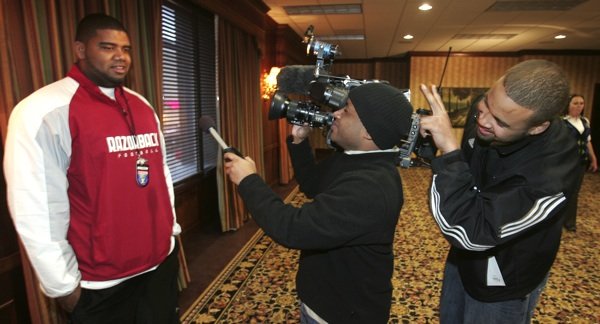 Arkansas tight end D.J. Williams, right, tries to make teammate Ray Dominguez laugh during a television interview by putting rabbit ears over a camera man after the team arrived at the Peabody Hotel in Memphis Sunday in preparation for the Liberty Bowl.