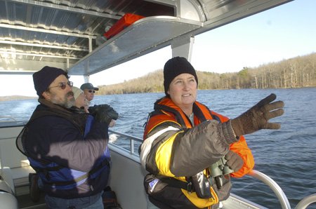 Terry Elder, right, volunteer coordinator at Hobbs State Park-Conservation Area, leads an eagle tour at Beaver Lake on Dec. 20. The park has a new 24-passenger pontoon boat and offers lake tours to see eagles on Wednesday, Saturday and Sunday.
