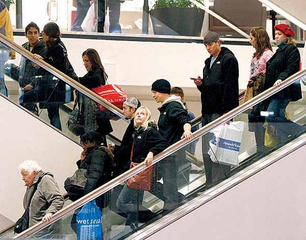 In this file photo made Dec. 19, 2009, shoppers ride escalators at Water Tower Place in Chicago.  Holiday shoppers spent a little more this season, according to data released Monday