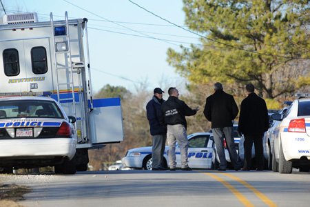 Fayetteville Mayor Lioneld Jordan, left, Fayetteville crime scene investigator John Brooks, Fayetteville Police Chief Greg Tabor and Detective Mike Reynolds wait Monday along Lake Sequoyah Drive after a man barricaded himself in his home at 1026 S. Lake Sequoyah Drive in Fayetteville.