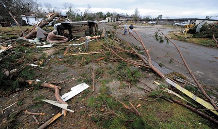 Destroyed houses, overturned vehicles and pine trees litter a street Thursday, Dec. 24, 2009, after a severe storm crossed Lufkin, Texas, Wednesday night. The East Texas town struck by an apparent tornado that damaged at least 50 homes and toppled 30 utility poles began a cleanup Thursday ahead of Christmas Eve.