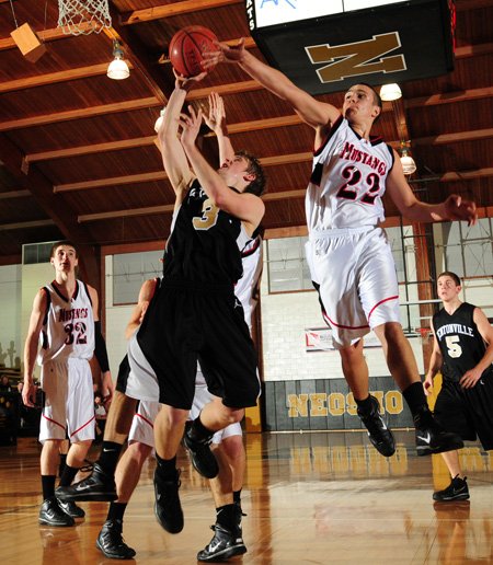 Bentonville’s Grant Higgins takes the ball to the basket under pressure from McDonald County (Mo.) guard Mason Haddock during Tuesday’s game at the 55th annual Neosho Holiday Classic in Neosho, Mo.