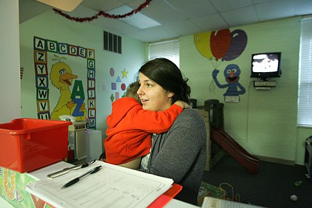 Kayla Norbash, a preschool child care worker at Northwest Arkansas Children’s Shelter, holds one of about 30 children in the shelter’s care. The shelter provides emergency housing for children throughout Arkansas removed from their homes because of abuse or neglect. Shelter administrators are coordinating a $9 million endowment fund in preparation for an expansion of services in 2011.