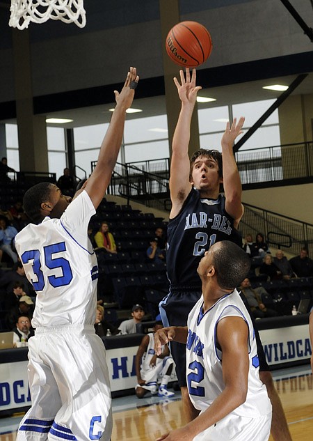 Springdale Har-Ber senior Michael Trexler shoots over Conway sophomore Xavier Clardy, left, and senior Kenyon McNeaill on Wednesday during the first half of the third-place game of the Har-Ber Holiday Basketball Tournament in Springdale. The Wildcats lost 66-46.
