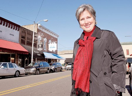 Betsy McGuire, executive director of Main Street Russellville, stands in front of busy storefronts downtown. Her organization is working on developing a master plan for the downtown district, which they believe will improve the quality of life for Russellville residents as well as draw tourism and jobs to the area.