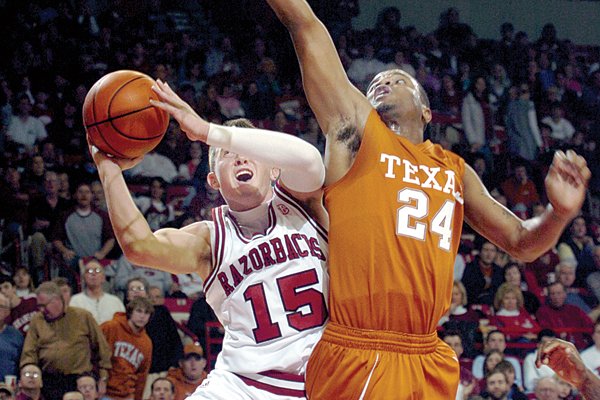 Arkansas guard Rotnei Clarke (15) is fouled by Texas defender Justin Mason as he drives to the basket in the first half Tuesday night in Fayetteville. Clarke led the Razorbacks with 24 points, but could not overcome the Longhorns in a 96-85 loss.  