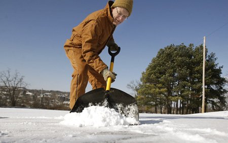 Daryl Kendrick shovels snow and ice from his driveway Monday on North Gregg Avenue in Fayetteville. Kendrick is pastor of Central Baptist Church, which is next door to the home.
