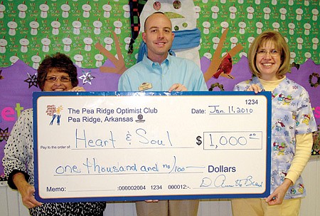 Justin Bradford, center, of the Pea Ridge Optimist Club, presented a check for $1,000 to Cheryl Tillman, left, and nurse Val Colburn, right, for Heart and Soul, an organization to minister to children’s needs.
