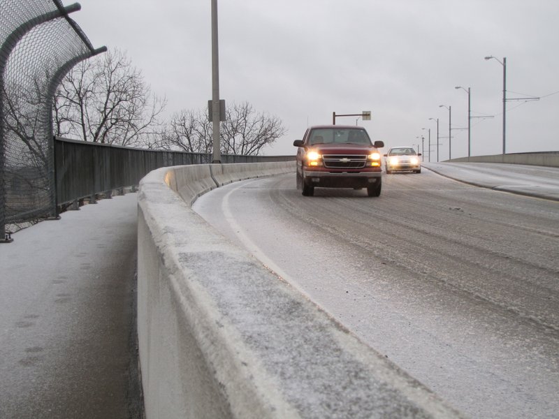 Vehicles drive over a sleet-covered Main Street bridge from North Little Rock to Little Rock Friday morning.