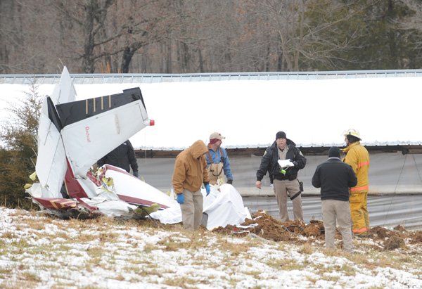  Officials with the Washington County Sheriff's Office collect information at the site of a plane crash Saturday, Feb. 6 north of Winslow that claimed four lives.
