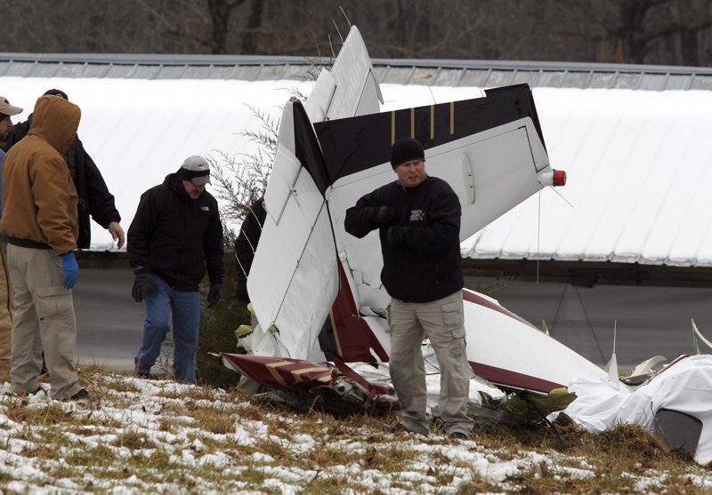 Investigators examine the wreckage of a small Beechcraft airplane Saturday afternoon that crashed in the Brentwood Mountain area near Winslow.