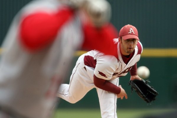 Arkansas starting pitcher Mike Bolsinger delivers the first pitch of the season against Ball State on Friday at Baum Stadium in Fayetteville.