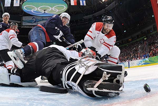  USA's Zach Parise (9) scores past Switzerland's goalie Jonas Hiller and Switzerland's Thierry Paterlini (23) in the third period of a men's quarterfinal round ice hockey game at the Vancouver 2010 Olympics in Vancouver, British Columbia, Wednesday, Feb. 24, 2010. The USA won 2-0. 