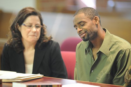 Johnny Ray Balentine, right, of Springdale smiles Tuesday alongside one of his attorneys, Leanna Houston, after being found not guilty of battering a Springdale police officer during an incident last year.