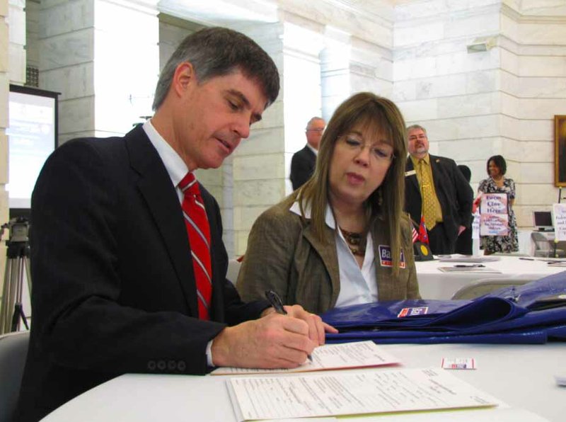Gilbert Baker, alongside wife Susan, fills out paperwork to run for U.S. Senate.