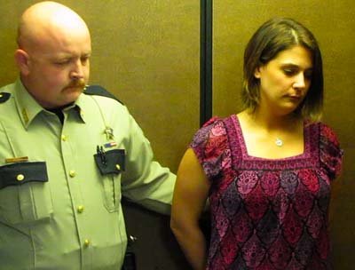 An officer escorts Amber Turley into an elevator at the Conway County Courthouse after she was sentenced to two years in prison as part of a plea deal in the deaths of her three sons.