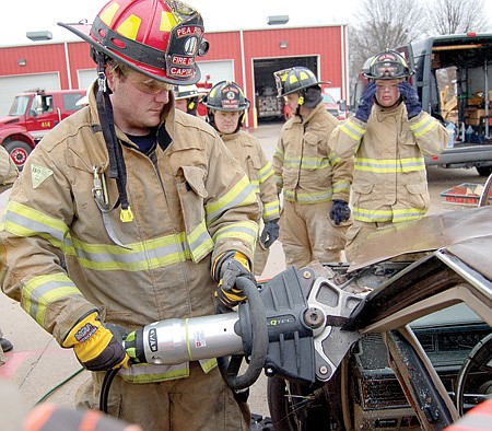Pea Ridge Fire Department Captain Brian Johnson illustrated the use of the Jaws of Life cutting tool to Pea Ridge firefighters during a training event Saturday, March 13. Watching were Brian Cogdill, Jeremy Hanna and Justin Collins.