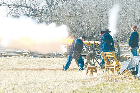 Members of the Northwest Arkansas Historical Association fire a canon Saturday near Elk Horn Tavern at Pea Ridge National Military Park.