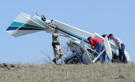 Madison County emergency responders look over the scene of a small airplane crash Thursday afternoon just east of the Huntsville airport runway. The pilot was killed in the crash when the plane went down in a field next to county road 5663. The pilot was the only person in the plane at the time of the crash.