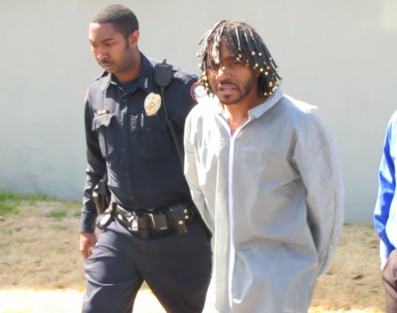 Police escort shooting suspect Harry Porter from the downtown detective office and into a patrol car bound for the Pulaski County Detention Center.