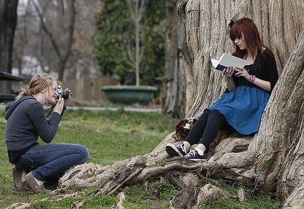  Claudia Hall, 14, focuses her camera while taking a portrait of Haley Zega,15, both of Fayetteville, Sunday afternoon at Wilson Park in Fayetteville. Hall said she was using her grandfather&#x27;s film camera and shooting the portrait for the fun of it. 