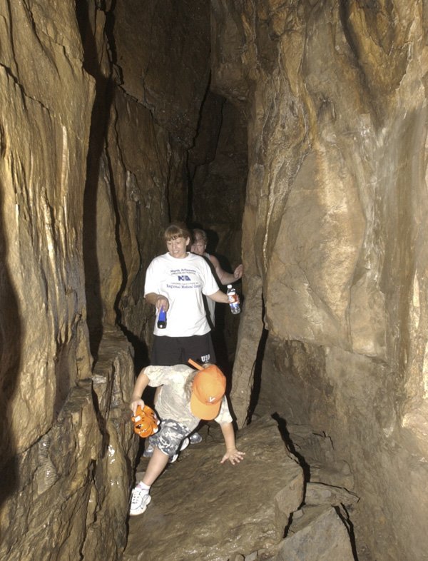Visitors make their way through Devil’s Den Cave in this 2005 photo. Devil’s Den Cave and Devil’s Ice Box will close indefinitely April 16 to prevent the spread of white-nose syndrome killing large numbers of bats.