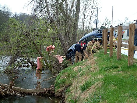 Firefighters from Bentonville and Bella Vista work to removed two women trapped inside a Toyota Corolla on Monday after it veered out of control, went through an unoccupied office building, jumped a walking trail and slammed into a tree.
