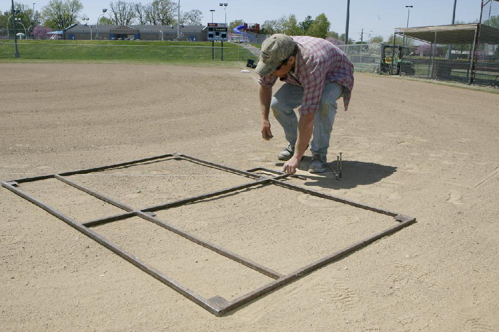 Arkansas Democrat-GazetteBOB COLEMAN--41210--Tell (cq) Peasley of Bentonville prepares to chalk the batters box on field one at Memorial Park in Bentonville Monday afternoon. Peasley works with the Bentonville Parks and Recreation Department.