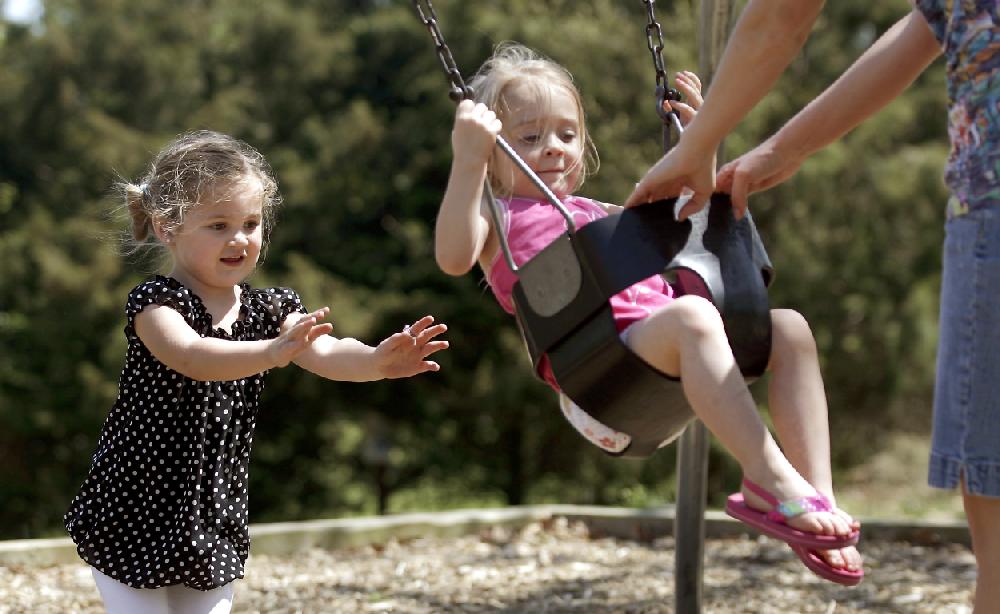 Arkansas Democrat-GazetteJASON IVESTER --041210--Reese Powell (left), 3, of Prairie Grove gives a push while Nikki Hardman (right) of Springdale pulls her daughter, Emma Hardman, 4, Monday on the swings at the Prairie Grove Battlefield Park. The girls were out enjoying the weather at the park with Reese's mother, Olivia Powell, and Nikki's other daughter, Madi Hardman, 15 months.