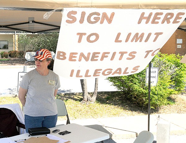 Jan Lea from Secure Arkansas seeks signers Tuesday to a petition to limit benefits to illegal immigrants. Lea set up her petition booth at the Bentonville Church of Christ, a polling place for the school district millage election.