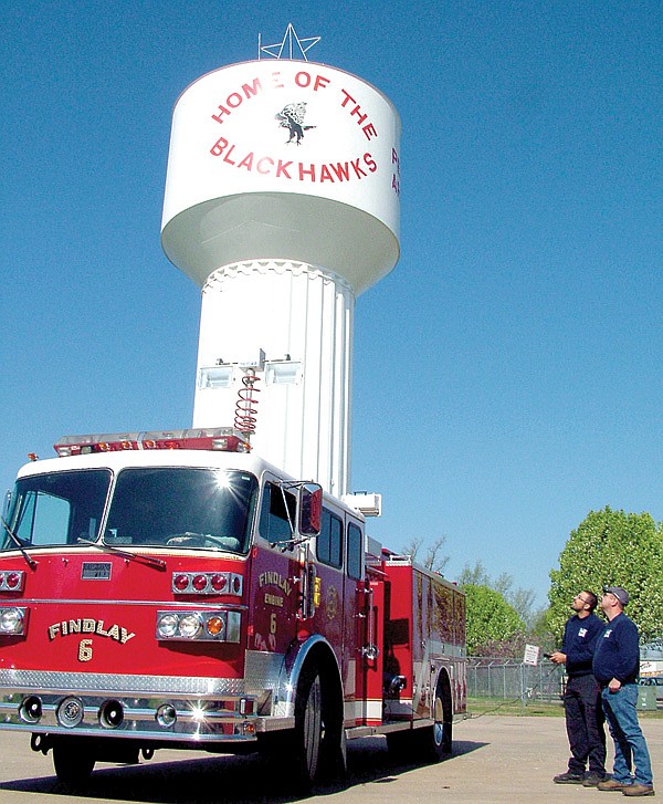 Assistant Fire Chief Andy Fletcher and Capt. Joshua King raise and rotate the emergency scene lights on the new Sutphen fire truck recently purchased by Pea Ridge Fire Department.