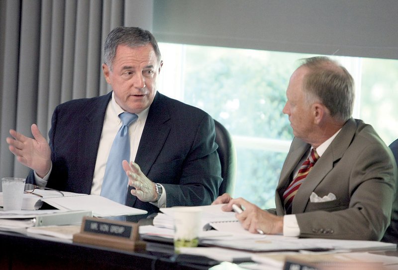 University of Arkansas Board of Trustees members' Sam Hilburn (left) and Jim Von Gremp confer during a trustee meeting Friday in Little Rock. The board voted to raise tuition fees, with Hilburn being the only member to vote against it.