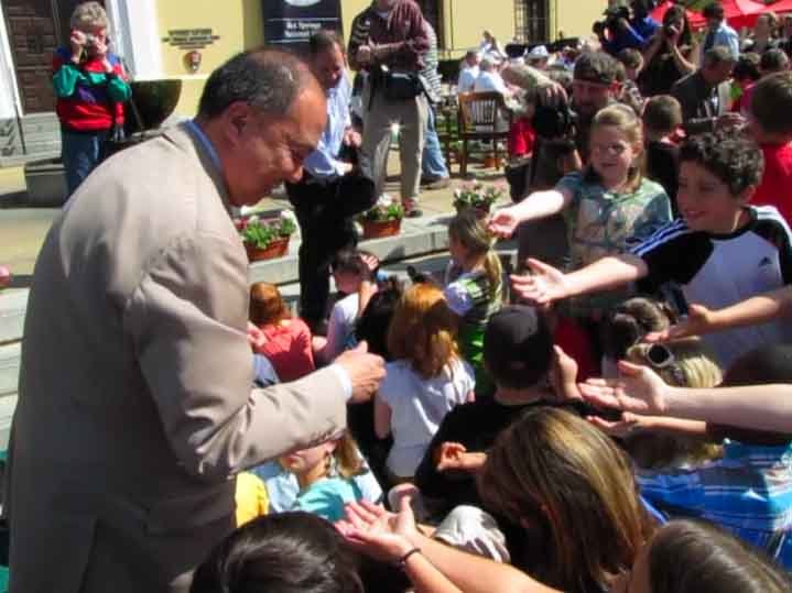 U.S. Mint Director Edmund Moy hands out new Hot Springs quarters to children after a ceremony Tuesday marking the release of the coins.