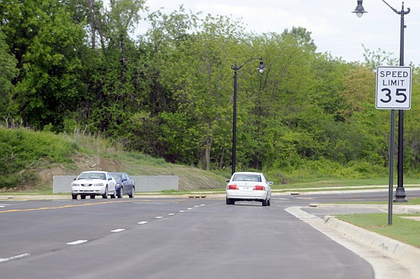 Cars drive Tuesday on Eighth Street near Melissa Drive in Bentonville. The project opened for traffic after the city spent almost $3.47 million to create the five-lane central corridor between Southwest 14th Street and Central Avenue.