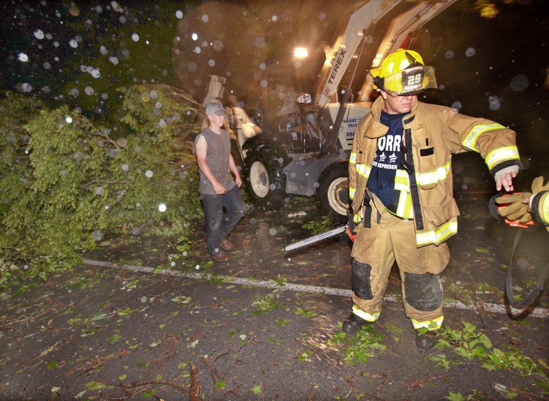 Arch Street firefighters work on clearing a fallen tree blocking the Pratt Rd exit on Interstate 530 after strong winds hit the area Friday night.