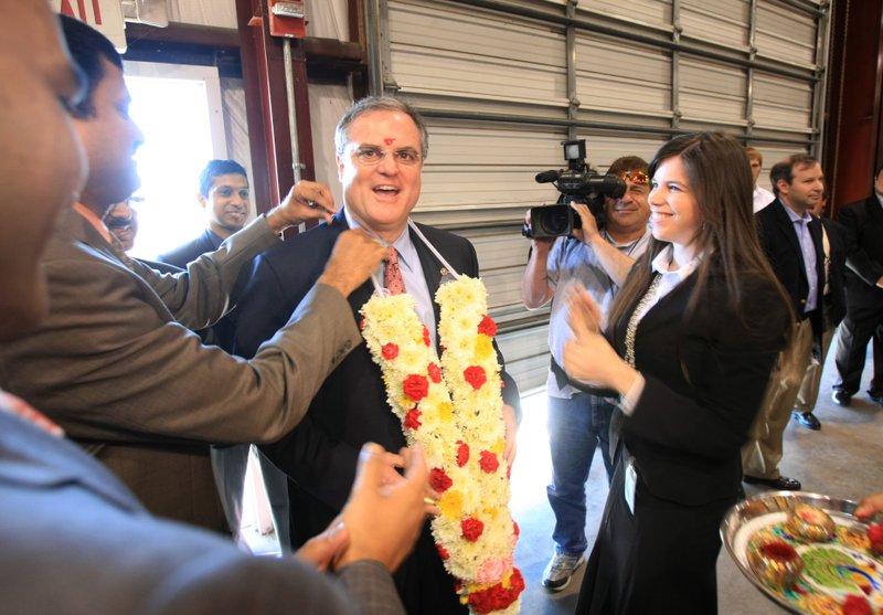 Sen. Mark Pryor is given flowers as part of a traditional Indian greeting at Welspun Monday before a news conference to announce the addition of 230 jobs at the company's plant in Little Rock. 