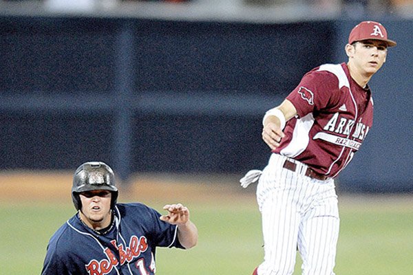 Arkansas second baseman Bo Bigham (right) forces out Mississippi’s Taylor Hightower (left) and throws to first for a double play during the Razorbacks’ 3-2 loss to the Rebels on Saturday in Oxford, Miss.
